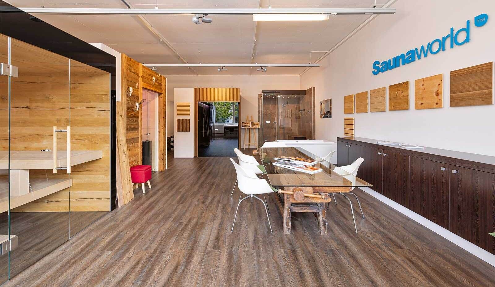 Der einzigartige Tisch im Eingangsbereich besteht aus einer antiken Hobelbank und einer modernen Glasplatte. Er symbolisiert, was Sauna World anbietet: Tradition mit Moderne, Handwerk und Technik – das Beste aus beiden Welten.