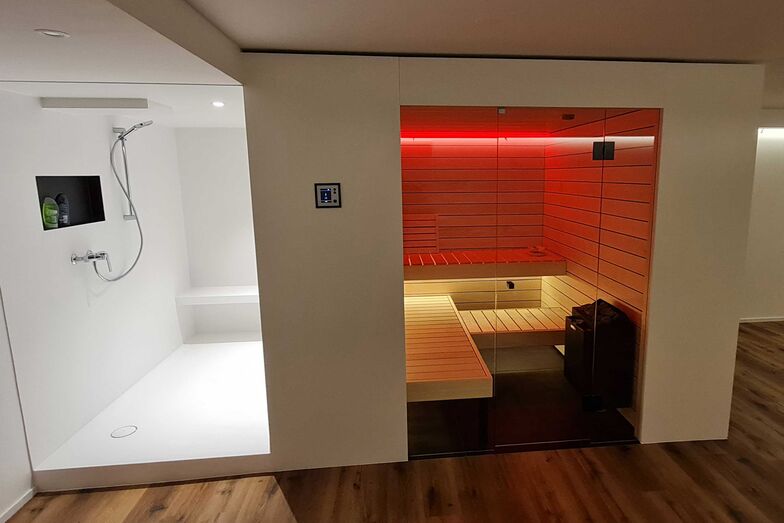 Die Bio-Sauna überzeugt in hellem Espenholz. Die Saunabänke sind für einen optimalen Liegekomfort gefedert. Das indirekte LED-Licht sorgt für Stimmung. Ging Saunabau AG.