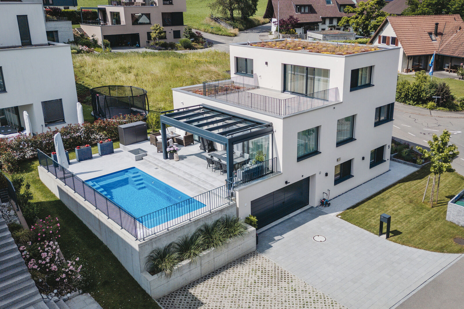 Klare Linien und viele ­Fenster machen das ­Einfamilienhaus mit Pool attraktiv.