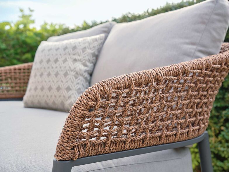 «Enna» ist eine Gartenlounge und ebenfalls in verschiedenen Grössen und Farben verfügbar. Das dunkle Aluminiumgestell bildet eine langlebige Basis. Durch die sanften Rundungen wird die Härte ausbalanciert. Das handgeflochtene Seil in der Farbe «Brown Oak» verstärkt den Effekt. Eine gelungene Kombination aus eleganter Moderne und natürlicher Wärme.