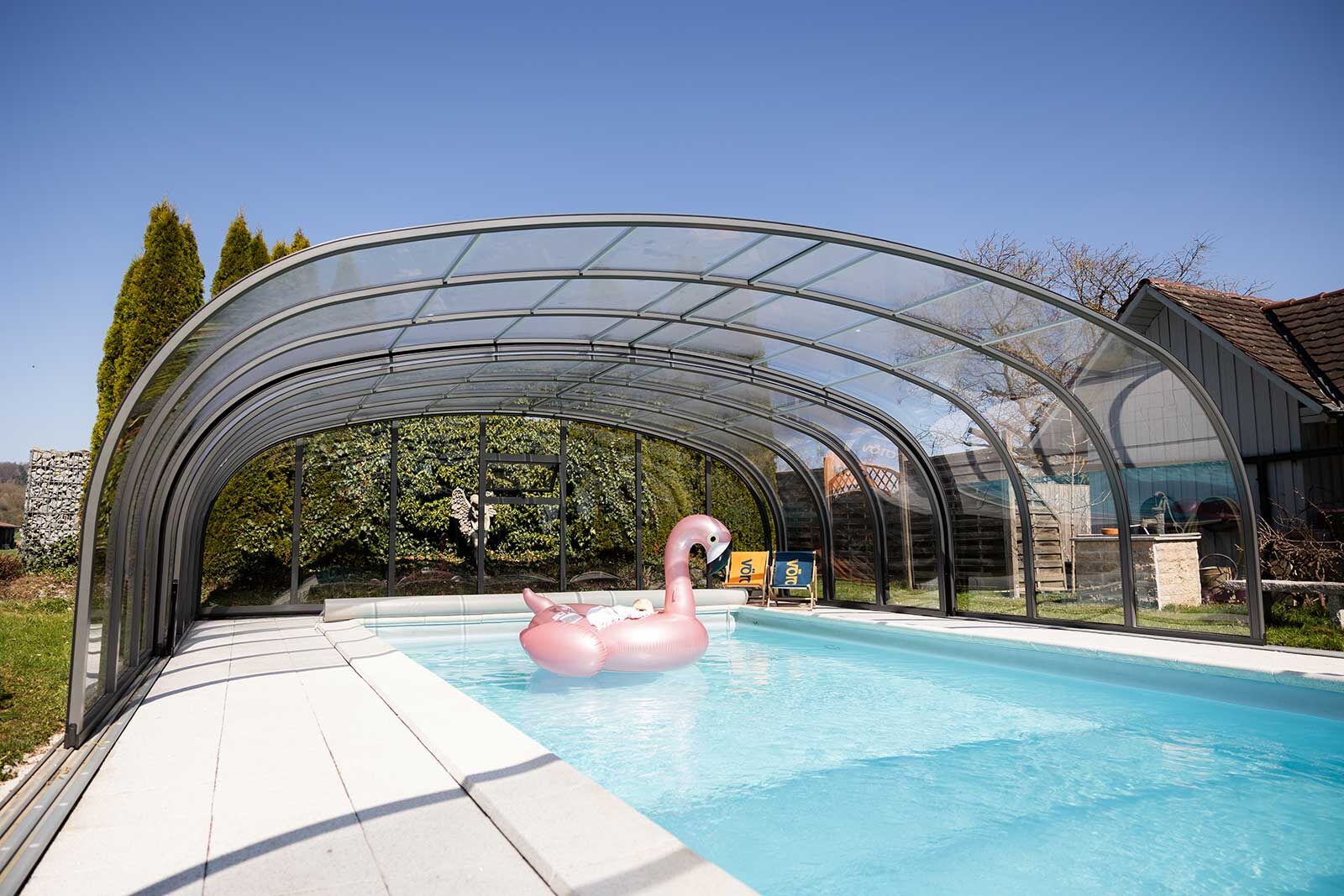 Die grosse Poolhalle «Prestige» überdacht nicht nur das Becken, sondern auch einen grosszügigen umliegenden Raum. Mit einer Höhe von 2,8 Metern und Abmessungen von 8 x 13 Metern verdient die Poolhalle die Bezeichnung XXL-Halle. Im Sommer, oder auch nur zum Lüften, können die Elemente einzeln verschoben oder sogar komplett hinter dem Pool abgestellt werden.