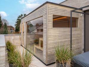 Diese massgefertigte Lösung von Sauna World passt perfekt auf die Terrasse. Die Sauna endet bündig zur Tür in die Wohnung und die Aussenverkleidung harmoniert mit der Hausfassade. So ist die Kabine kein Fremdkörper, sondern fügt sich gelungen in ihr Umfeld ein. Sauna World AG.